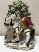 A Continental encrusted china figure group modelled as a gentleman and a lady sitting on a garden