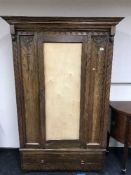 An Edwardian oak single door wardrobe