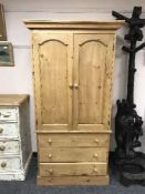 A pine double door wardrobe fitted with three drawers