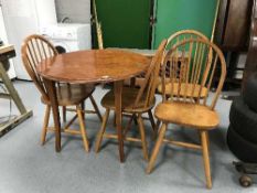 A circular pine kitchen table and four chairs