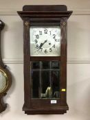 An early twentieth century wall clock with pendulum and key