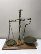 A set of brass tobacco scales on mahogany board with weights