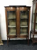 A Victorian inlaid mahogany bow fronted double door display cabinet