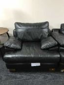 A contemporary black leather settee with matching armchair