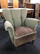 An early twentieth century Deco style armchair upholstered in green and striped fabric