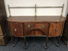 An inlaid mahogany bowfronted regency style sideboard with brass rail back