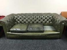 A green buttoned leather three seater Chesterfield settee (one cushion missing)