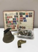 A brass hand bell together with a Victory stamp album and a tub containing carved brass walking