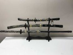 A set of three graduated Samurai swords on stands