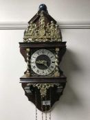 A continental wall clock with pendulum and brass pear drop weights