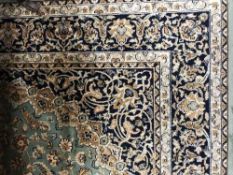 A fringed Keshan Persian carpet 230 cm x 160 cm on green ground