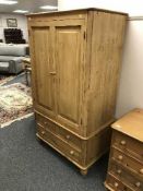 A pine double door child's wardrobe fitted with three drawers
