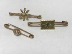 Three gold brooches - 1 15ct and 1 set with emerald
