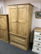 A pine double door wardrobe fitted with three drawers