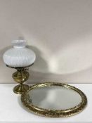 A brass oil lamp with chimney and shade and a oval gilt framed mirror