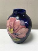 A small Moorcroft vase decorated with tubelined flowers on blue ground,