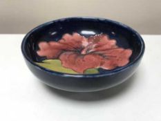 A small Moorcroft dish, decorated with amaryllis on blue ground,