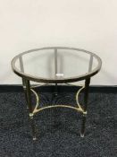 A circular brass glass topped coffee table