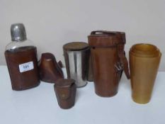 A set of six graduated flasks in a leather holder together with a further set of five flasks,