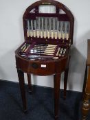 A Victorian inlaid mahogany d-shaped canteen containing a set of stainless steel and plated cutlery