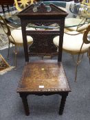 A pair of Victorian carved oak hall chairs