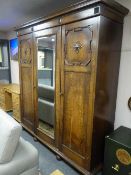 An Edwardian oak triple door wardrobe