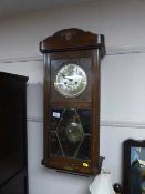 An Edwardian wall clock with pendulum