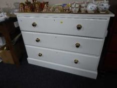 A painted three drawer chest with brass handles
