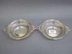 A pair of silver bon bon dishes with pierced sides and floral swag handles, 197.8g.