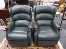 A pair of green leather electric reclining lounge chairs
