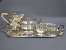 A silver Art Deco four piece tea service and tray, together with a small pair of silver sugar nips,