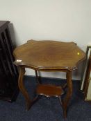 A shaped Edwardian two tier occasional table