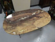 An oval marble topped coffee table on a chrome base