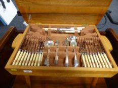 A mid 20th century teak cutlery table containing plated and stainless steel cutlery