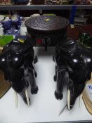A carved hardwood plant table with elephant legs and two carved ebony figures of elephants