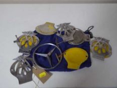A collection of AA badges and a Mercedes Benz car badge