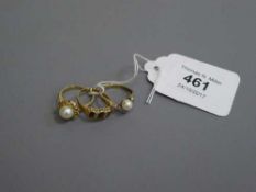 Three gold rings, two set with diamond chips.