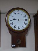 A contemporary walnut circular wall clock with fusee movement