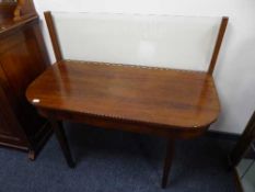 A Victorian d-shaped table with glass splash back