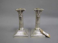 A pair of Corinthian column candlesticks with sconces, height 16cm, loaded.