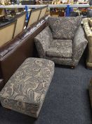 A contemporary floral upholstered armchair and footstool