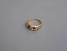 An early twentieth century 18ct gold three stone diamond and ruby ring, 4.4g, ring size M.