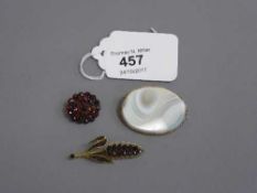 Three antique brooches - two garnet and one agate in gold settings.