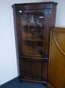 An oak glazed door corner cupboard