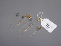 A collection of eight lapel pins, examples of 14k and platinum moonstone, paste, micro mosaic,