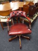A red button leather swivel Captain's armchair