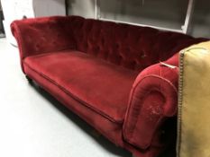 An early twentieth century red buttoned dralon drop end settee