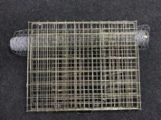 A roll of chicken wire and a folding dog cage