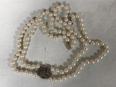 A fine double strand pearl choker necklace with old cut diamond pendant and gold clasp,