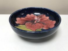 A small Moorcroft dish, decorated with amaryllis on blue ground,